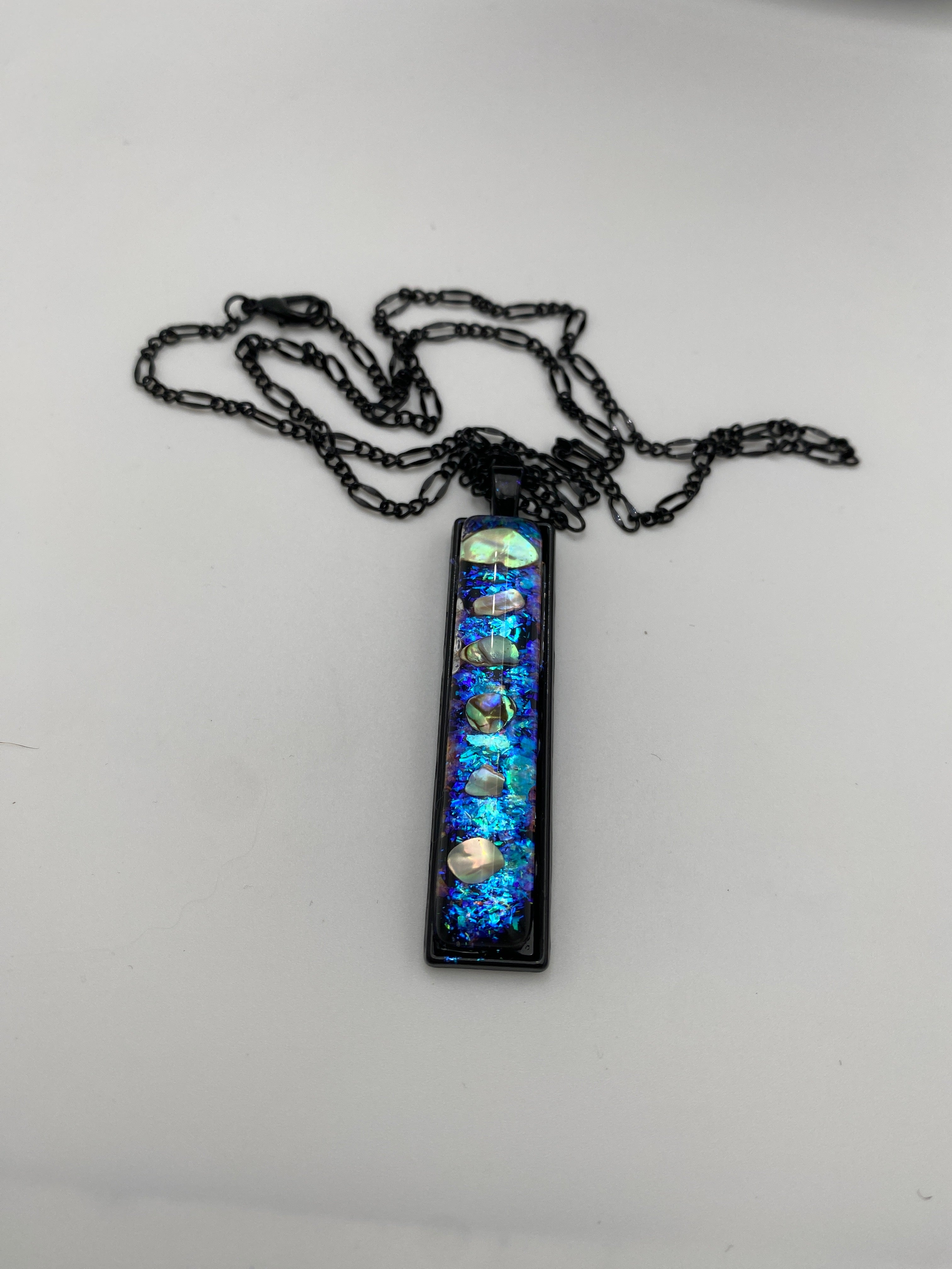 Necklace with a rectangular pendant featuring blue and silver elements on a white background